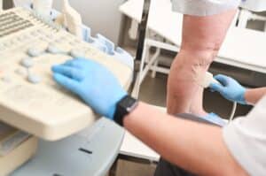Vein specialists performs a lower extremity ultrasound on a patient with varicose veins